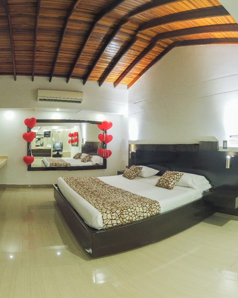 Suite Gold con decoración especial de ocasión: globos de corazón rojos junto al espejo y a la cama, bajo el techo de vigas de madera (no es la ambientación estándar)