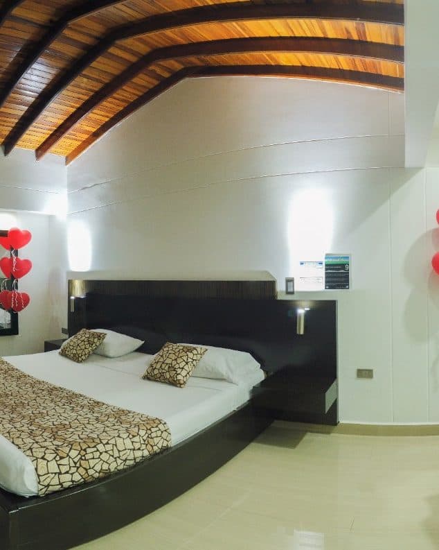 Suite Gold con decoración especial de ocasión: cabecera de la cama entre apliques de luz, con globos de corazón a los lados (no es la ambientación estándar)