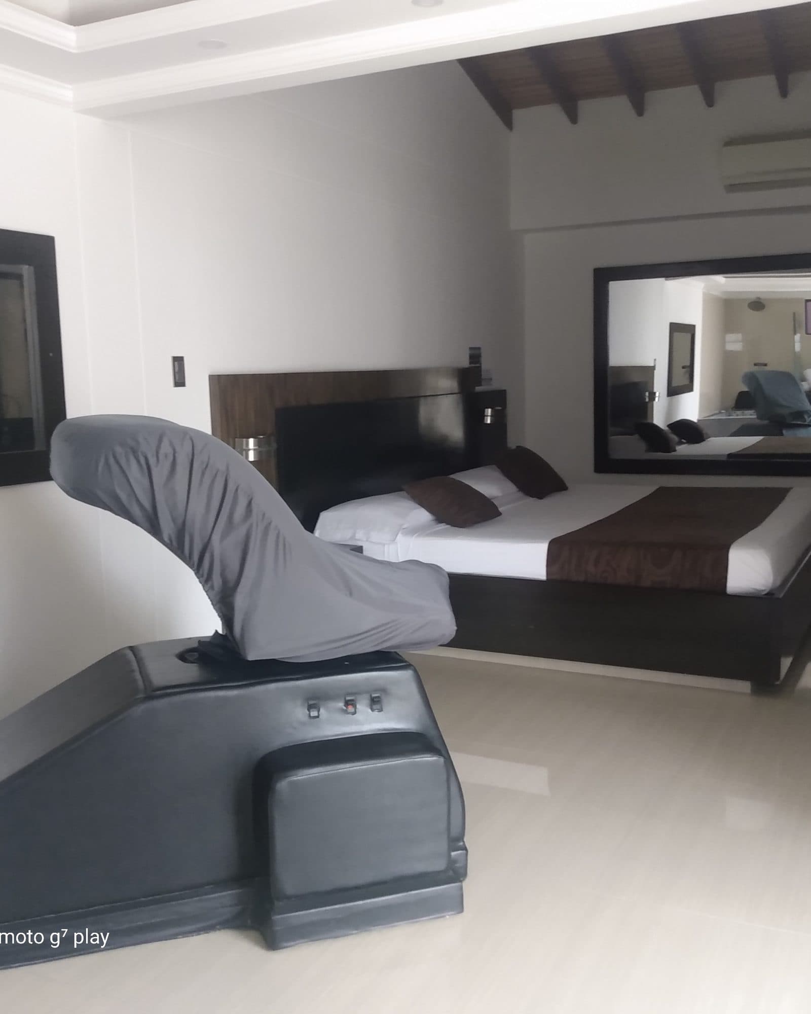 Suite Silver: silla del amor junto a la cama, con el espejo de pared al lado