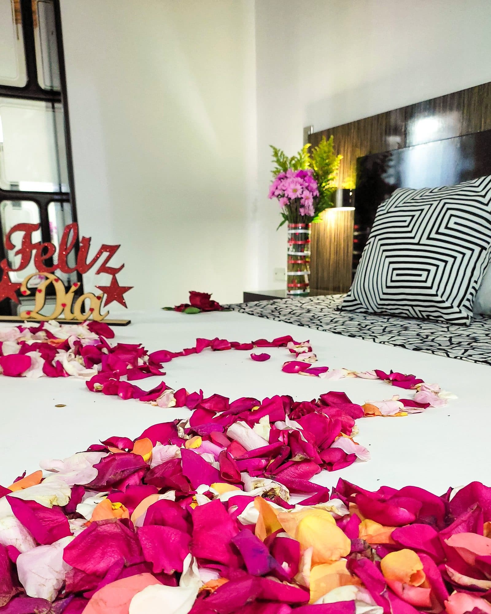 Suite Soho con decoración especial de ocasión: letrero 'Feliz Día', pétalos de rosa y flores sobre la cama (no es la ambientación estándar)