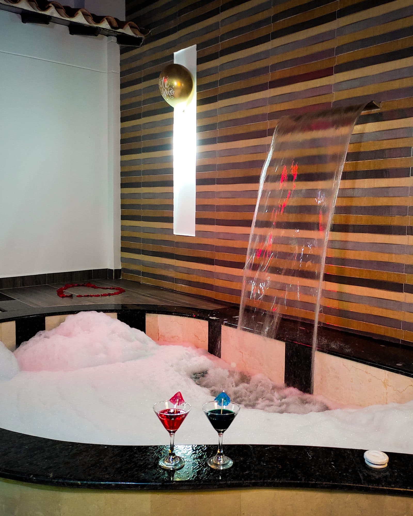 Suite Soho con decoración especial de ocasión: jacuzzi con espuma y cascada, cócteles y un corazón de pétalos en el piso (no es la ambientación estándar)
