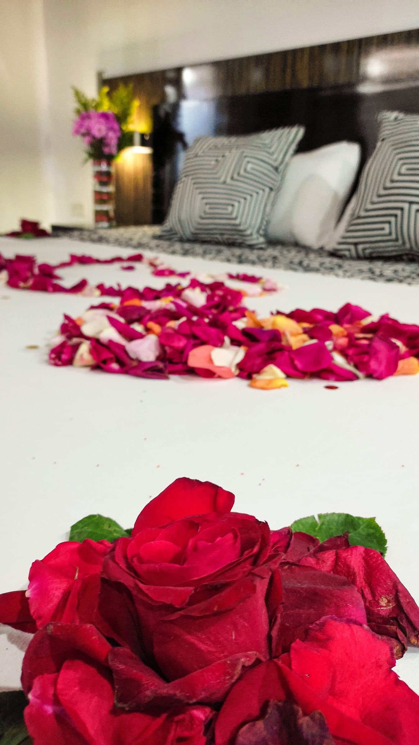 Cama decorada con pétalos y rosas rojas para una fecha especial